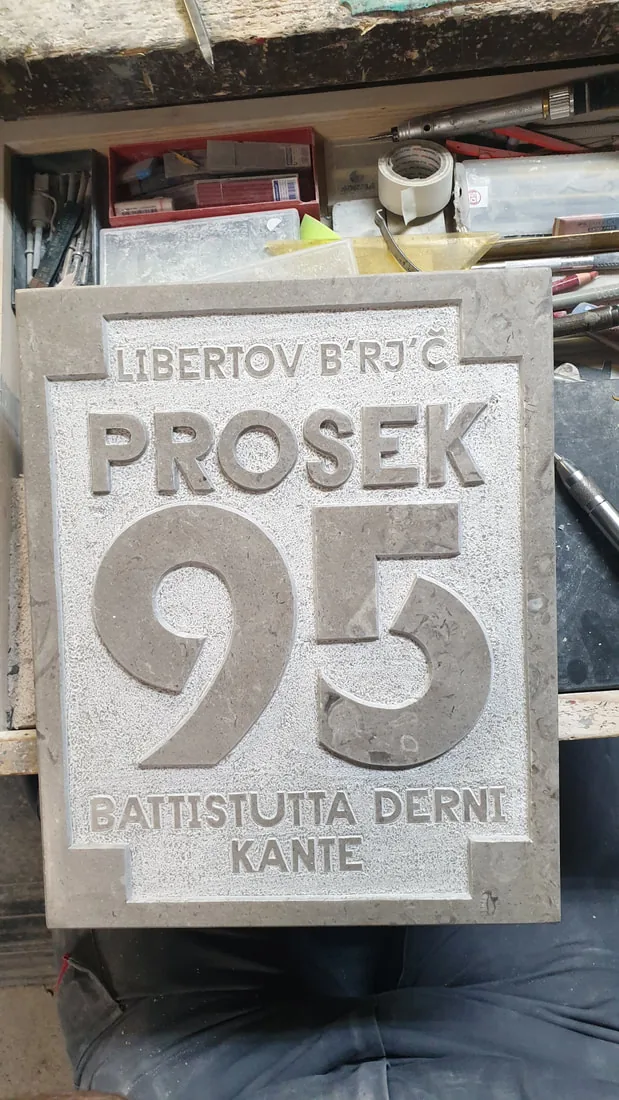 Kamnita hišna tabla z reliefno številko 95 in imeni