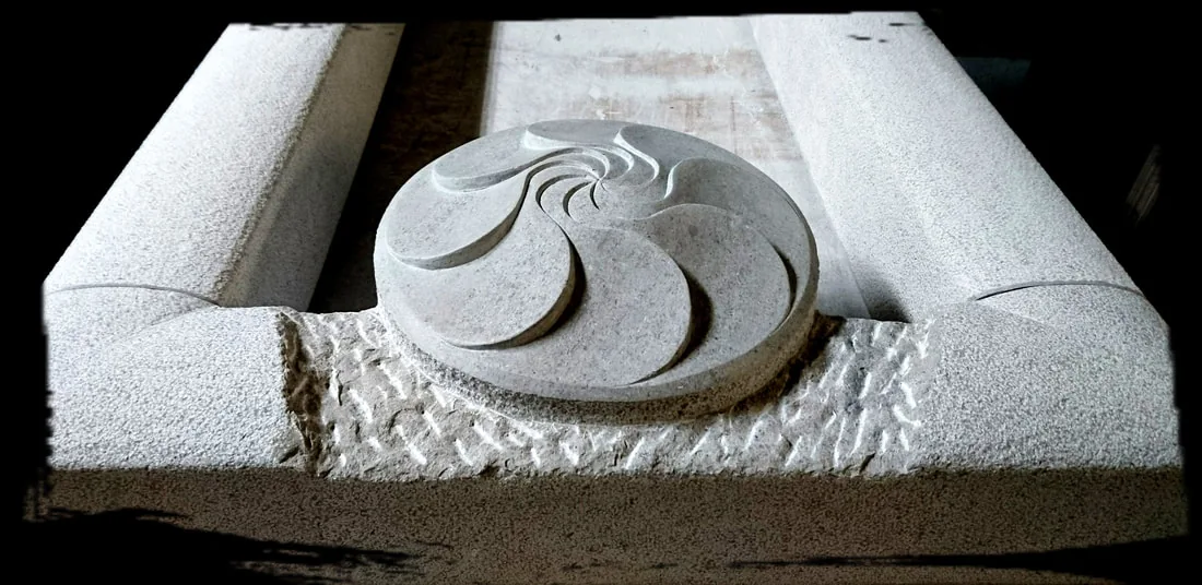 Okrogel spiralni relief na kamnitem podstavku