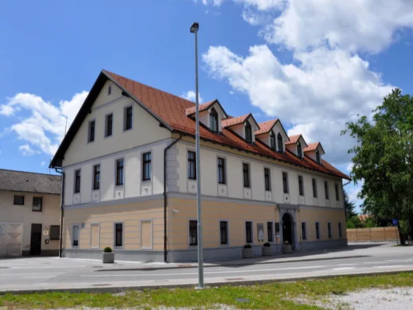 Stavba Upravne enote Ribnica z opečno streho in frčadami