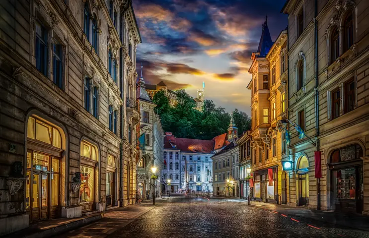 Stritarjeva Street at dusk, with Ljubljana Castle on the hill